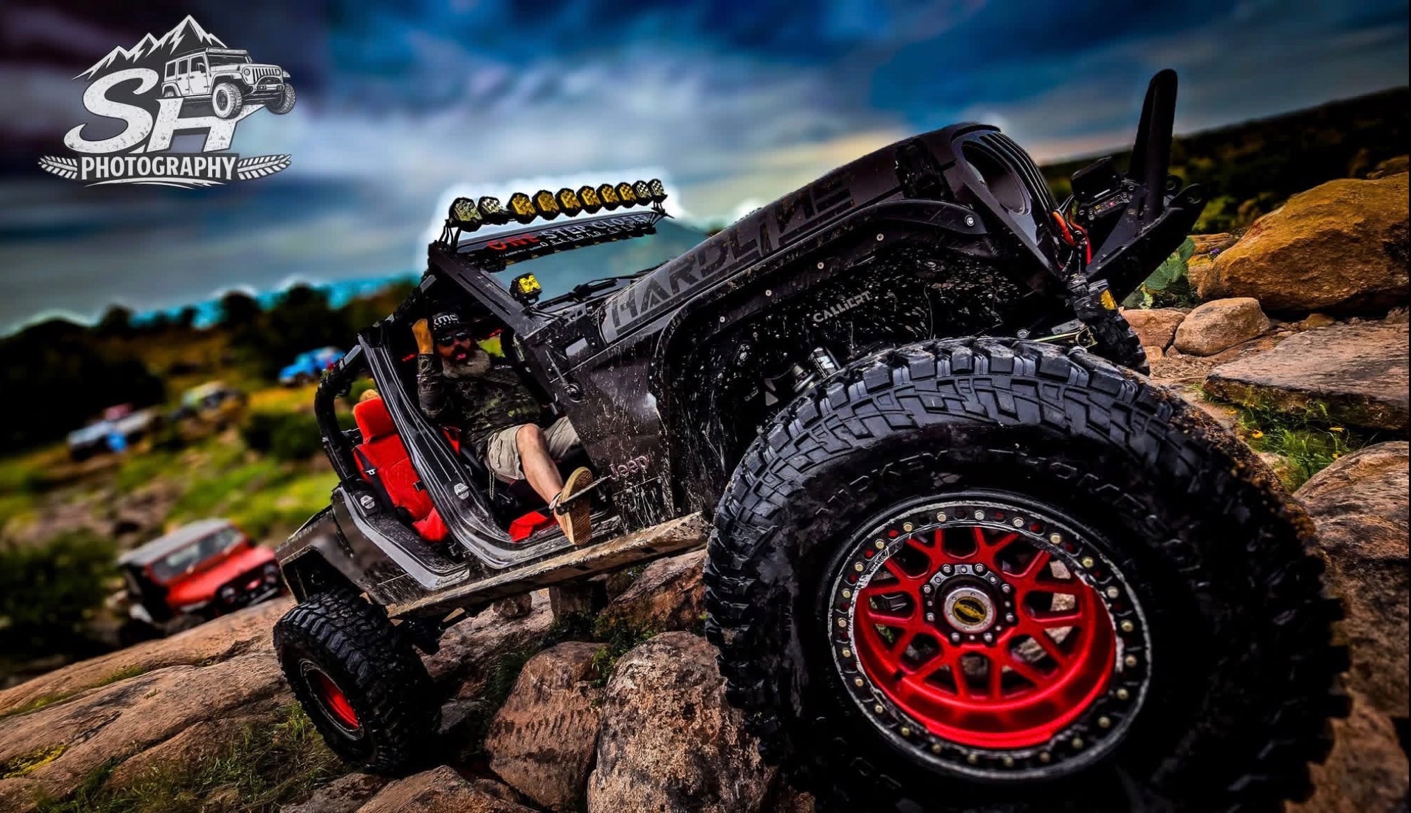 Red beadlock Jeep on rocks